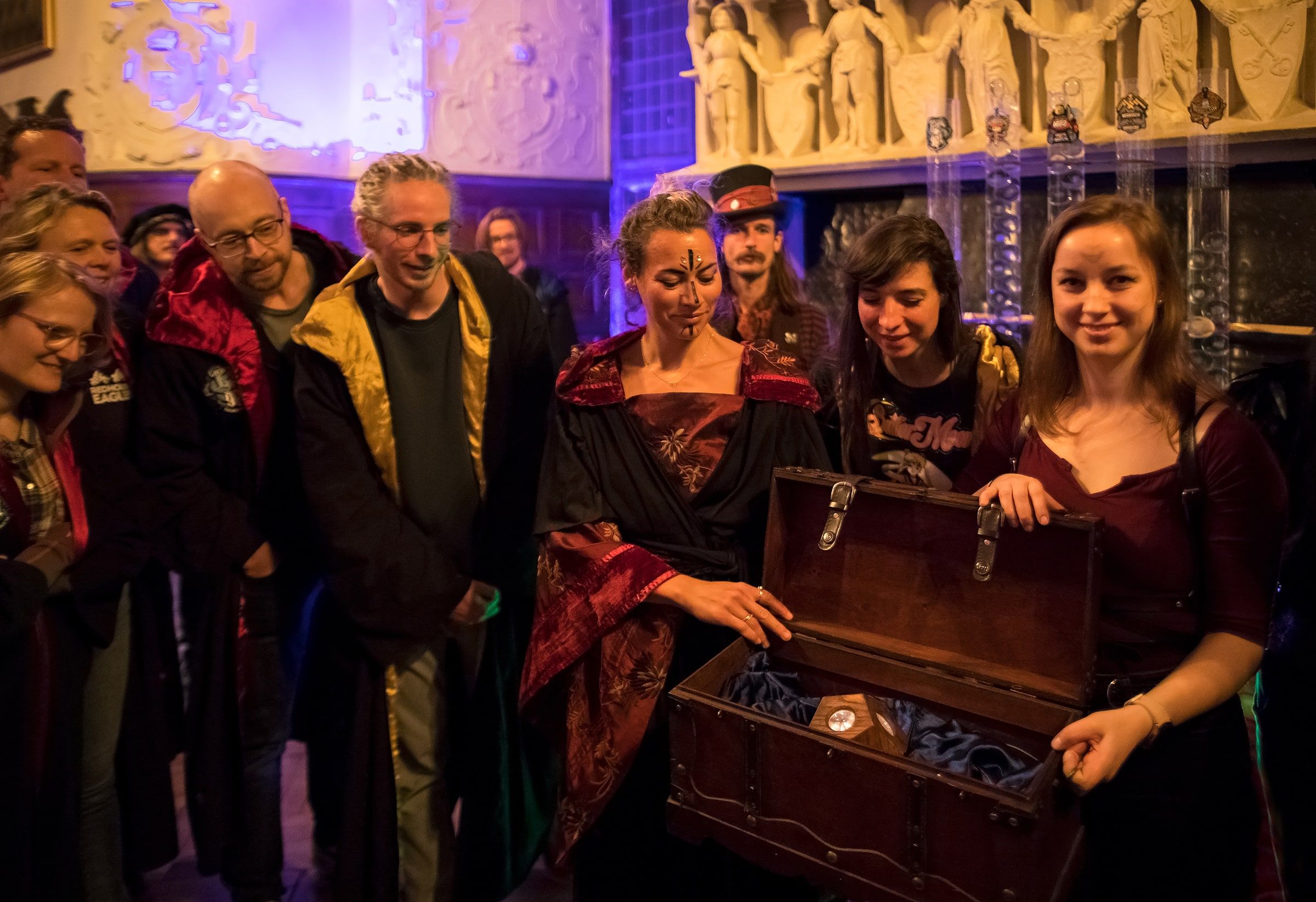 Players in robes gather around an open wooden chest holding the Kernel during the closing ceremony