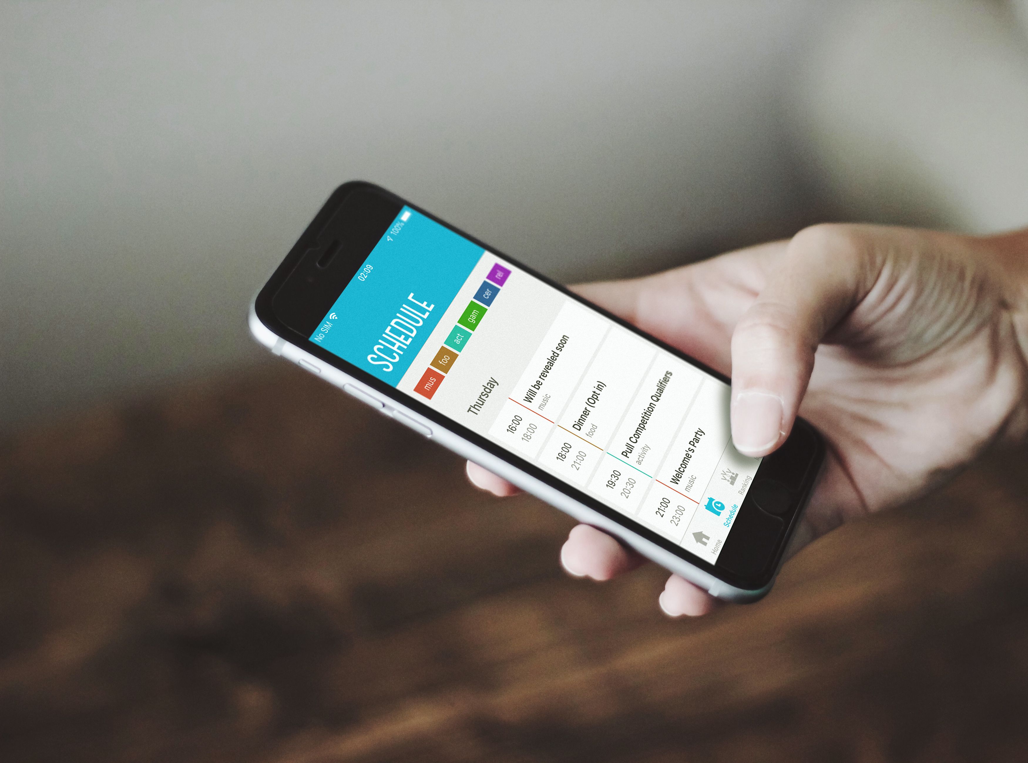 A hand holding a phone with the Windmill app open on the schedule